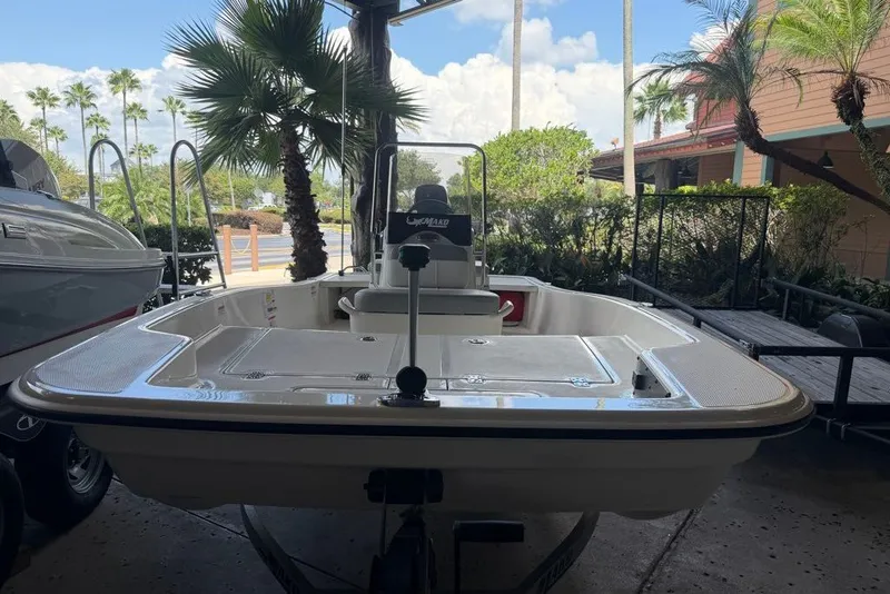 Slide: The Image of 2026 Mako Pro Skiff 15 CC boat displayed outdoors with palm trees in the background. - 1