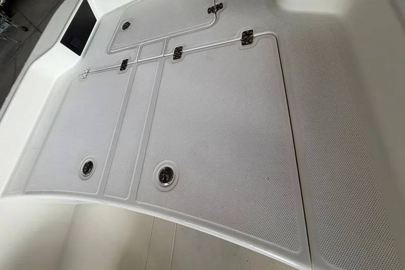 Slide: The Image of 2026 Mako Pro Skiff 15 CC boat deck with storage compartments and secure latches. - 60