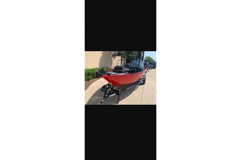 Slide: The Image of 2026 Tracker Pro Guide V-16 WT boat on trailer, red exterior, parked outdoors. - 10