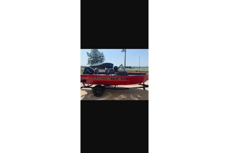 Slide: The Image of 2026 Tracker Pro Guide V-16 WT boat in vibrant red on a trailer. - 12