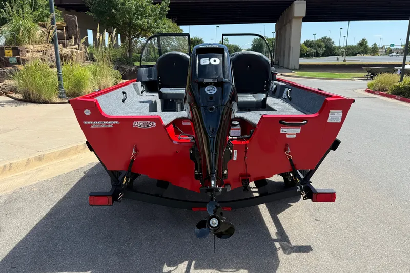 Slide: The Image of 2026 Tracker Pro Guide V-16 WT boat with 60 HP motor, parked outdoors. - 13