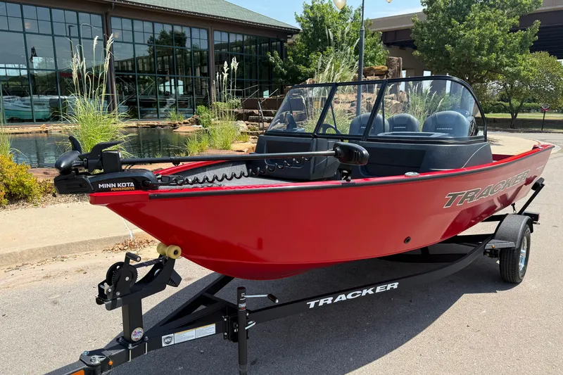 Slide: The Image of 2026 Tracker Pro Guide V-16 WT boat in vibrant red on a trailer, parked outdoors. - 23