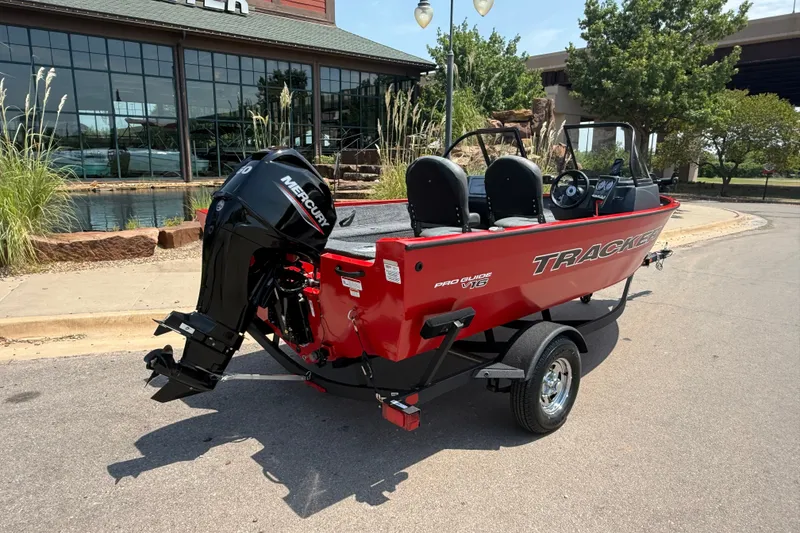 Slide: The Image of 2026 Tracker Pro Guide V-16 WT boat with Mercury engine, parked outdoors. - 16