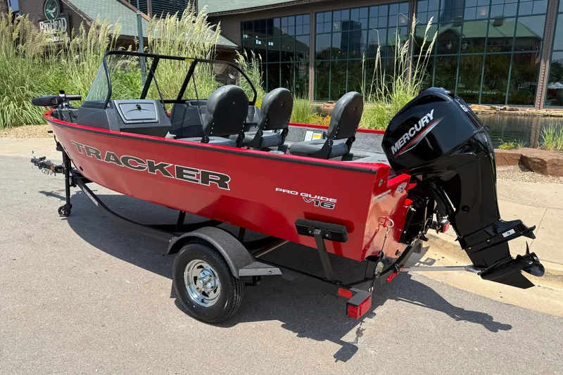 Slide: The Image of 2026 Tracker Pro Guide V-16 WT boat with Mercury engine, parked outdoors. - 24