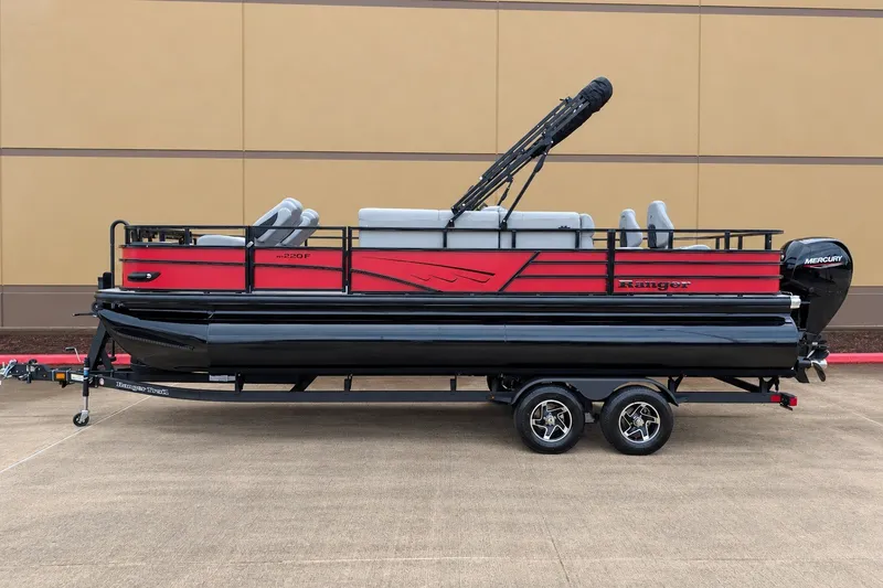 The Image of 2026 Ranger 220F pontoon boat with red and black design on a trailer. - 0