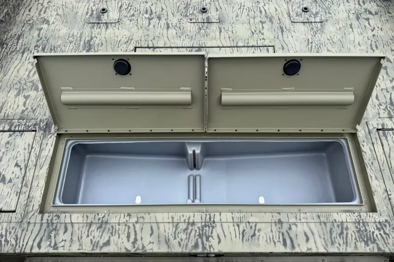 Slide: The Image of Open storage compartment on 2026 Tracker Grizzly 2072 CC boat, featuring camouflage design. - 6