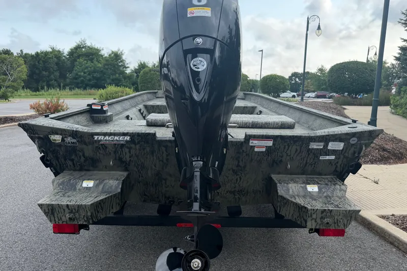 Slide: The Image of 2026 Tracker Grizzly 2072 CC boat with camouflage design, parked outdoors. - 5