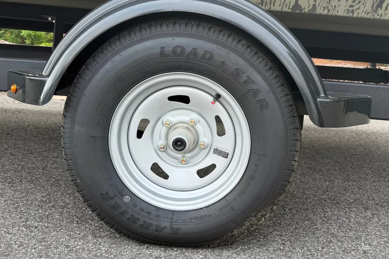Slide: The Image of Trailer wheel of 2026 Tracker Grizzly 2072 CC on asphalt surface. - 9