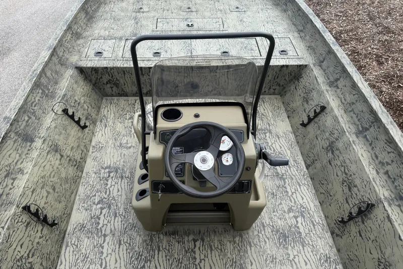 Slide: The Image of 2026 Tracker Grizzly 2072 CC boat interior with steering console and camouflage design. - 2