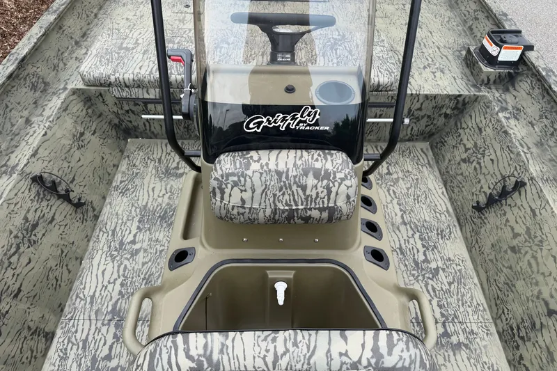 Slide: The Image of 2026 Tracker Grizzly 2072 CC boat interior with camouflage design and central console. - 4