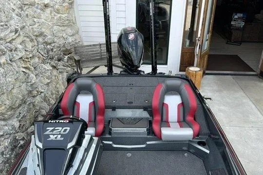 Slide: The Image of 2026 Nitro Z20 XL Pro boat with dual red and gray seats, parked near a stone wall. - 5