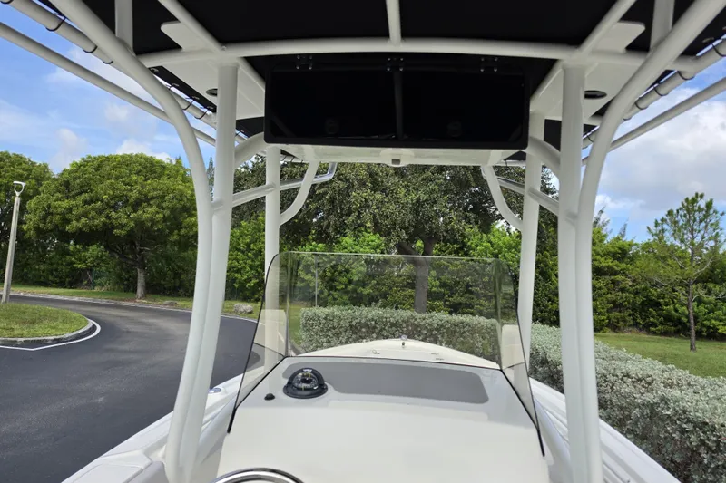 Slide: The Image of 2024 Mako 214 Center Console boat with T-top and windshield, parked outdoors. - 7