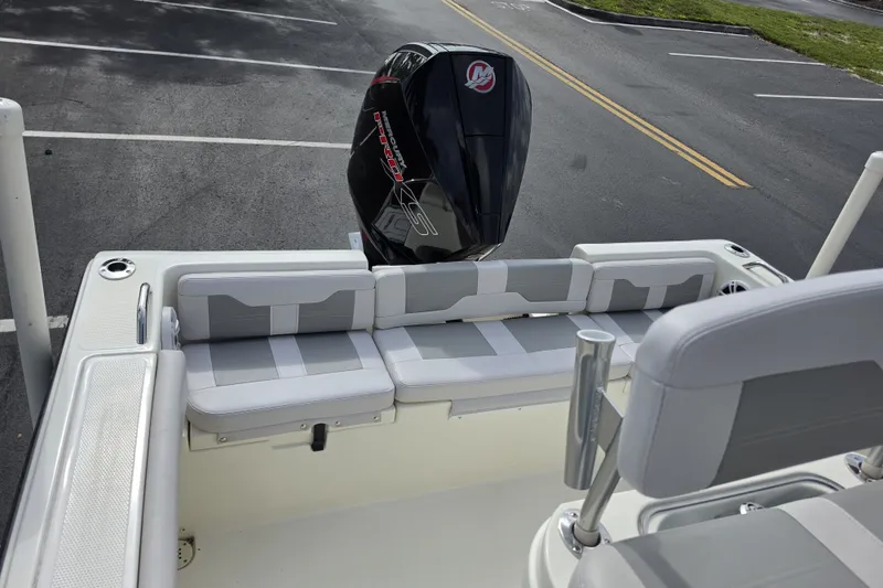 Slide: The Image of 2024 Mako 214 Center Console boat with cushioned seating and powerful outboard motor. - 19
