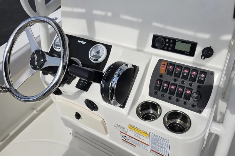 Slide: The Image of 2024 Mako 214 Center Console boat dashboard with steering wheel and control panel. - 12