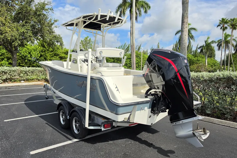 Slide: The Image of 2024 Mako 214 Center Console boat with outboard motor in a tropical setting. - 3