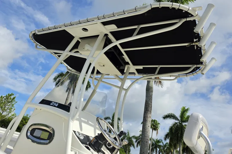 Slide: The Image of 2024 Mako 214 Center Console boat with T-top against a tropical sky backdrop. - 8