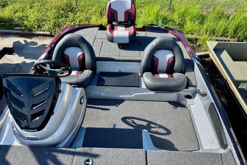 Slide: The Image of 2025 Nitro Z17 boat interior with three seats and steering wheel, parked outdoors. - 4