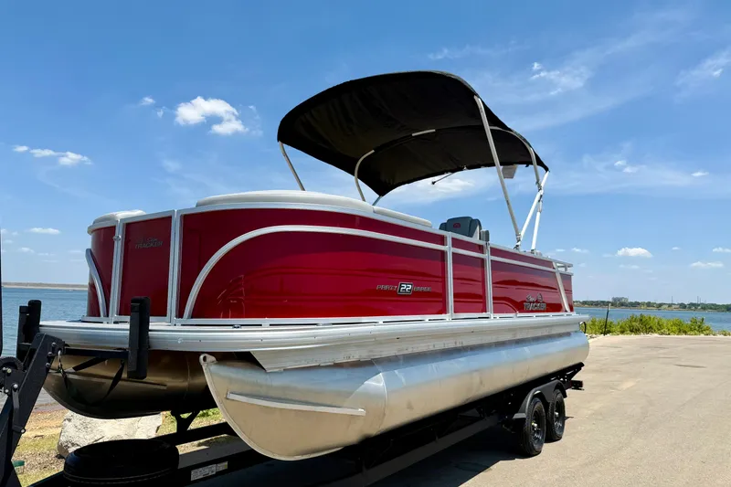 Slide: The Image of 2026 Sun Tracker Party Barge 22 RF DLX pontoon boat on trailer by a lake. - 15