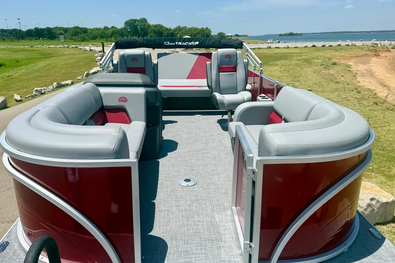 Slide: The Image of 2026 Sun Tracker Party Barge 22 RF DLX pontoon boat with spacious seating, docked by a lake. - 6