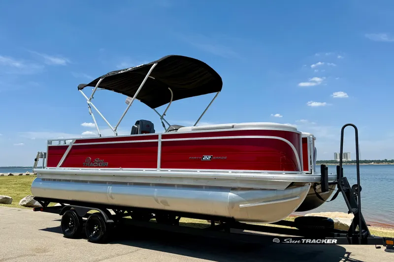 Slide: The Image of 2026 Sun Tracker Party Barge 22 RF DLX pontoon boat by the water. - 7