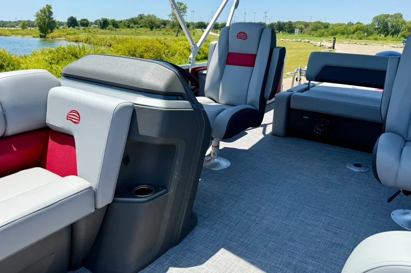 Slide: The Image of 2026 Sun Tracker Party Barge 22 RF DLX interior with plush seating and scenic lake view. - 10