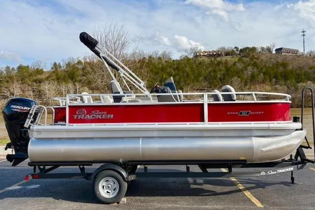 The Image of 2026 Sun Tracker Bass Buggy 18 DLX pontoon boat on trailer, red and silver design. - 0