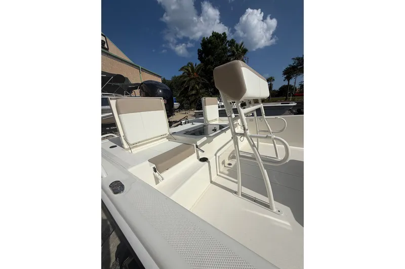 Slide: The Image of 2026 Mako Pro Skiff 19 CC interior with seating and console under a clear blue sky. - 5