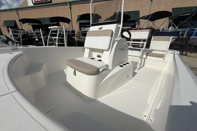 Slide: The Image of 2026 Mako Pro Skiff 19 CC boat interior with seating and steering console. - 3