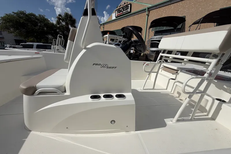 Slide: The Image of 2026 Mako Pro Skiff 19 CC boat interior with seating and steering console. - 2