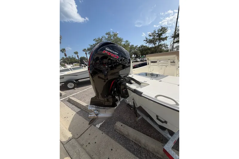 Slide: The Image of 2026 Mako Pro Skiff 19 CC with Mercury Pro XS outboard motor in a sunny parking lot. - 6