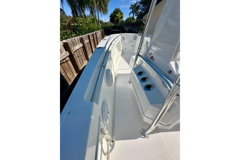 Slide: The Image of 2001 Contender 23 Open boat interior with console and seating, surrounded by lush greenery. - 23