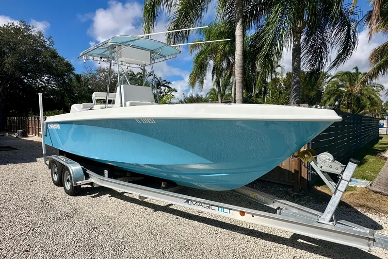 Slide: The Image of 2001 Contender 23 Open boat on trailer, parked outdoors with palm trees. - 6