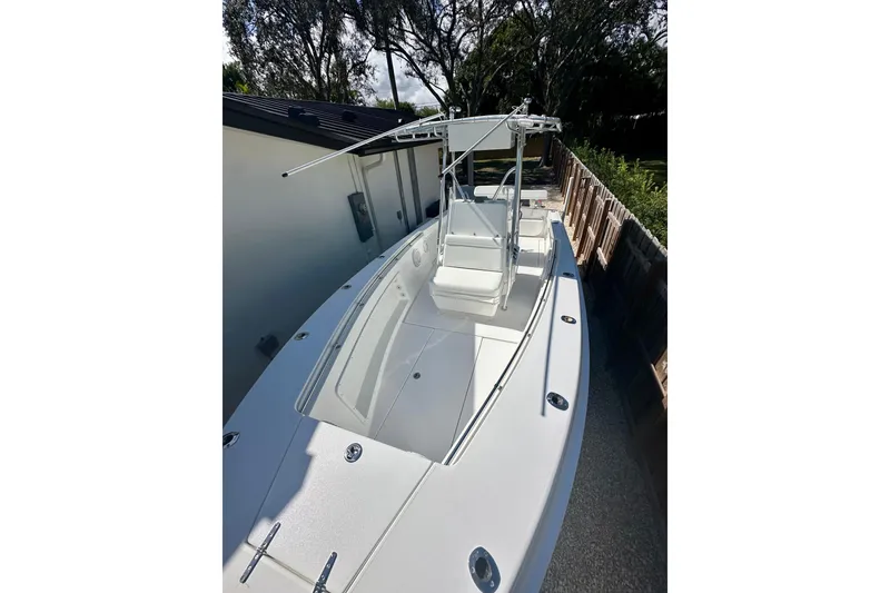 Slide: The Image of 2001 Contender 23 Open boat with T-top, parked beside a house. - 15