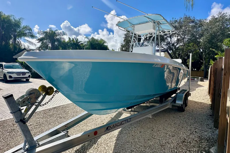 Slide: The Image of 2001 Contender 23 Open boat on trailer, parked outdoors under a sunny sky. - 8