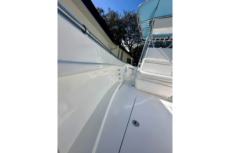 Slide: The Image of 2001 Contender 23 Open boat deck, featuring sleek white design and stainless steel railings. - 19