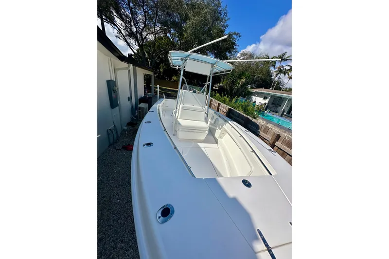 Slide: The Image of 2001 Contender 23 Open boat with T-top, parked outdoors near a house. - 16
