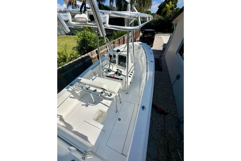 Slide: The Image of 2001 Contender 23 Open boat with center console, parked beside a house. - 30