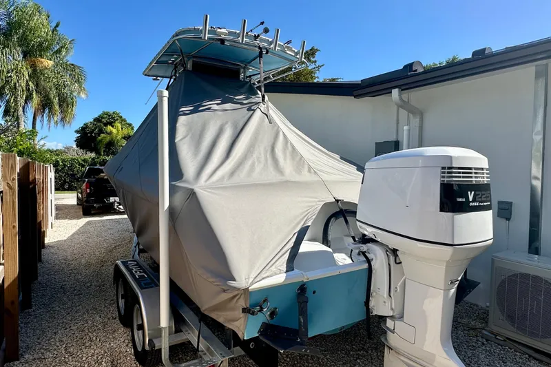 Slide: The Image of 2001 Contender 23 Open boat covered, parked on trailer with Yamaha V225 outboard motor. - 12
