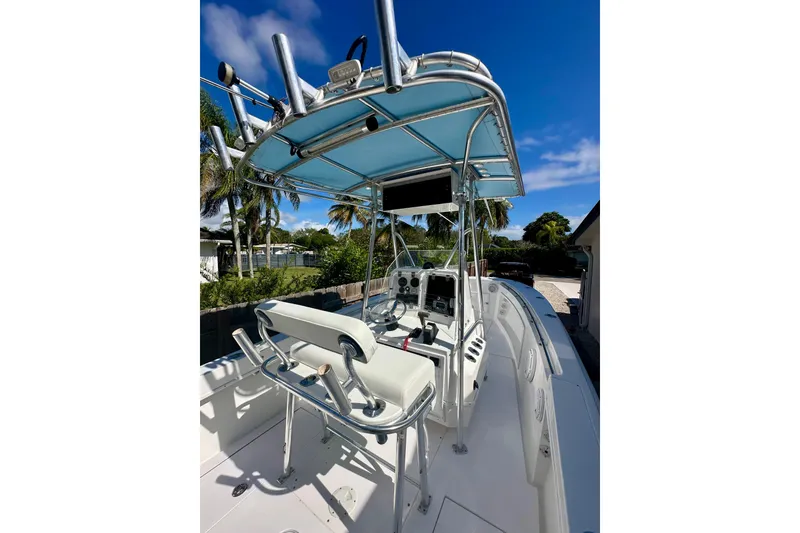 Slide: The Image of 2001 Contender 23 Open boat with T-top and helm, set against a sunny backdrop. - 27