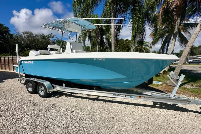 The Image of 2001 Contender 23 Open boat on trailer, parked under palm trees. - 0