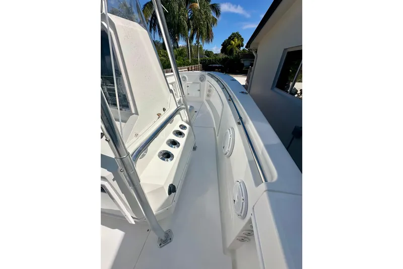 Slide: The Image of 2001 Contender 23 Open boat deck with rod holders and railing, surrounded by tropical scenery. - 24