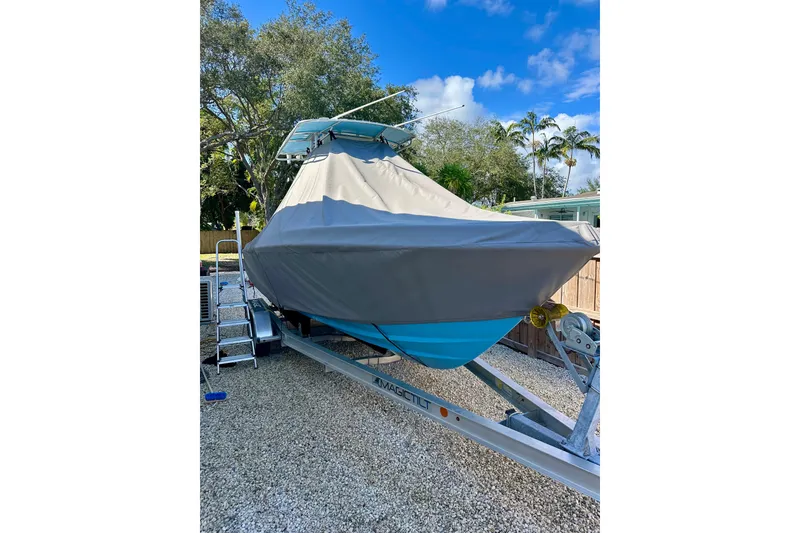 Slide: The Image of 2001 Contender 23 Open boat covered on trailer, parked outdoors. - 10