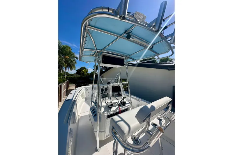 Slide: The Image of 2001 Contender 23 Open boat with T-top and helm, under clear blue sky. - 26