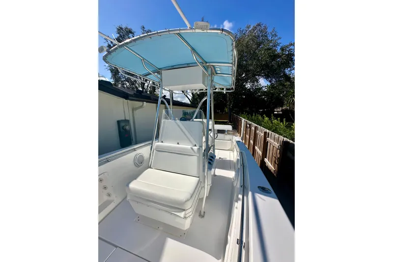 Slide: The Image of 2001 Contender 23 Open boat with blue canopy, white seating, and sleek design. - 22