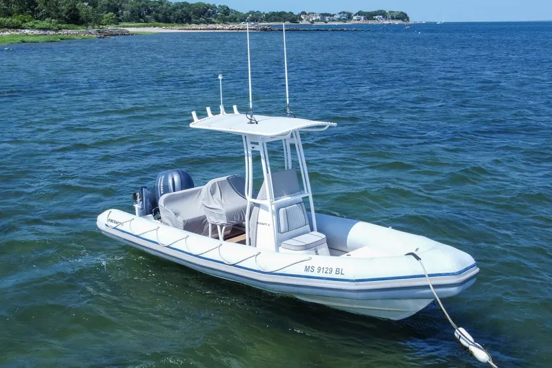 Slide: The Image of 2019 Ribcraft 6.8 boat on calm water near a scenic shoreline. - 1