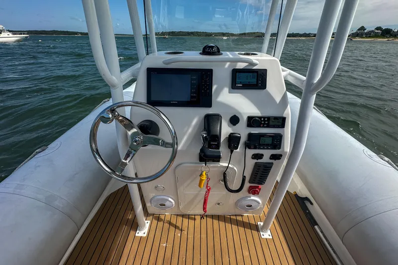 Slide: The Image of Cockpit view of a 2019 Ribcraft 6.8 boat with steering wheel and navigation equipment. - 11