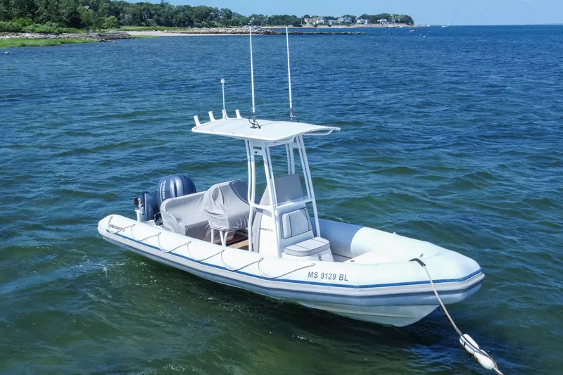 Slide: The Image of 2019 Ribcraft 6.8 boat on calm water near a scenic shoreline. - 1