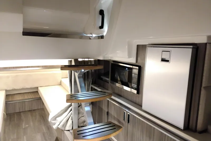Slide: The Image of Interior of 2023 Sea Ray Sundancer 320 Outboard with modern kitchenette and seating area. - 27