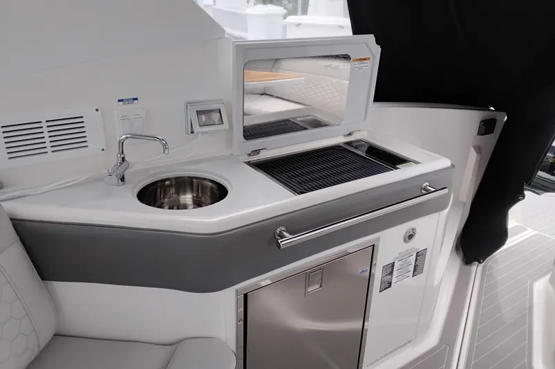 Slide: The Image of 2023 Sea Ray Sundancer 320 Outboard boat kitchenette with sink, grill, and storage. - 15