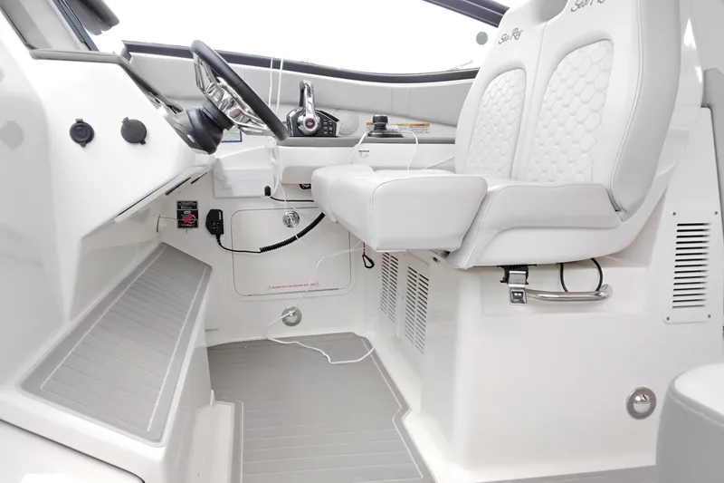 Slide: The Image of 2023 Sea Ray Sundancer 320 Outboard helm with modern controls and luxurious seating. - 7